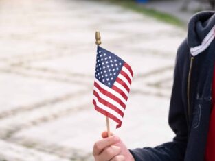 American flag in boy's hand outdoors. 4th july USA independence