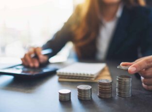 businesswoman-holding-and-stacking-coins-while-cal-2026-01-11-10-39-27-utc