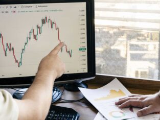A stock investor shows another investor the behavior of a stock on the stock market on the monitor. Concept economy, stocks, stock market.