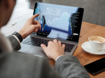Cropped image of business man sitting by table in cafe