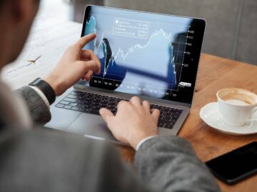 Cropped image of business man sitting by table in cafe