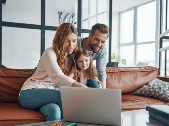 Young beautiful family with little girl bonding together and smi