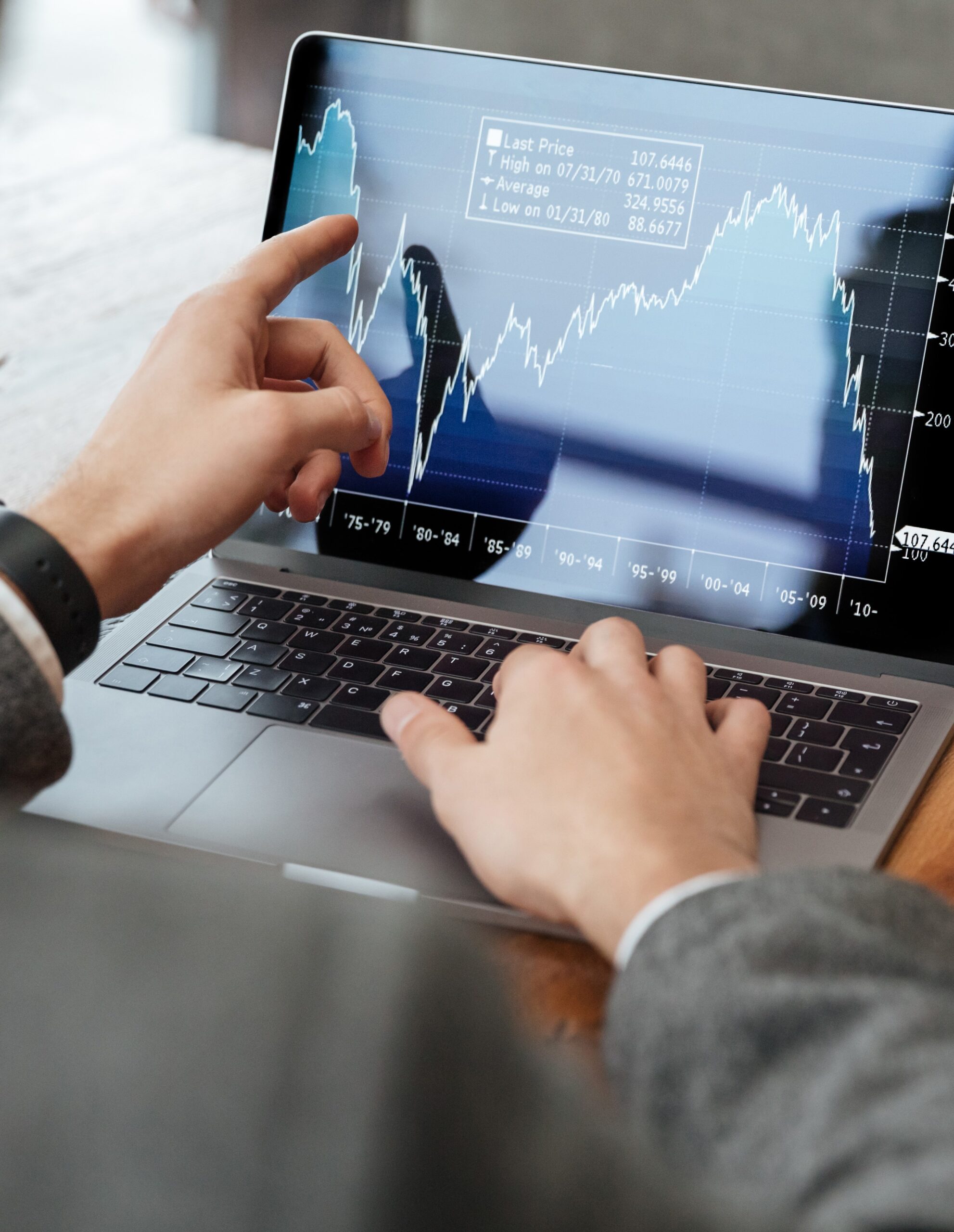 geerntetes-bild-des-geschaftsmannes-sitzend-durch-die-tabelle-im-cafe-und-indikatoren-auf-laptop-computer-analysierend6554